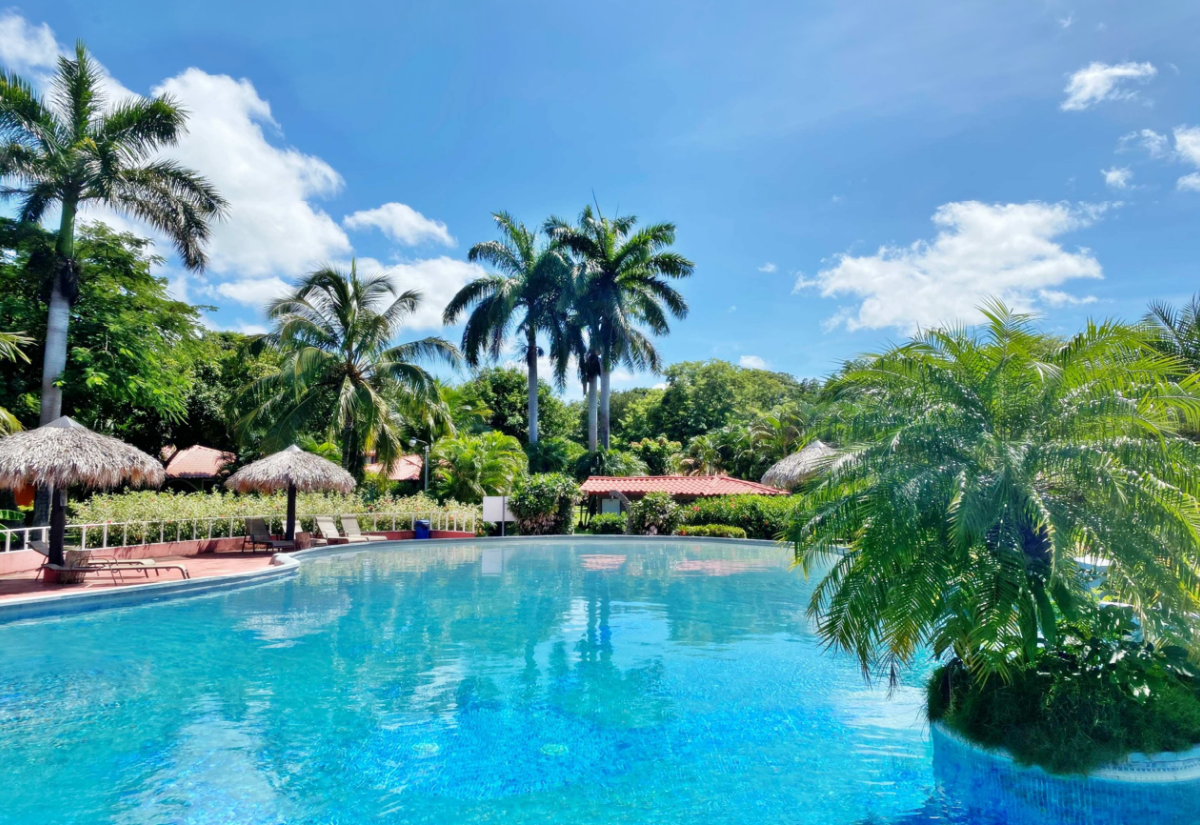 La piscina di Flor de Pacifico tra palme e ombrelloni